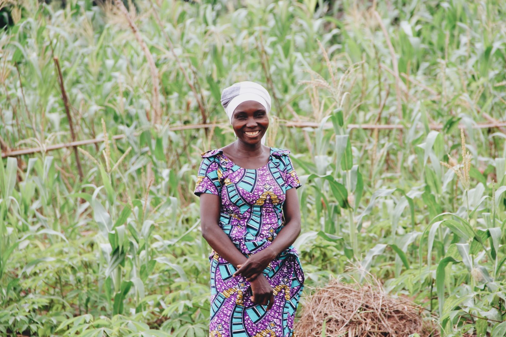 Anastazie smiles in front of her farm in Kakumba.